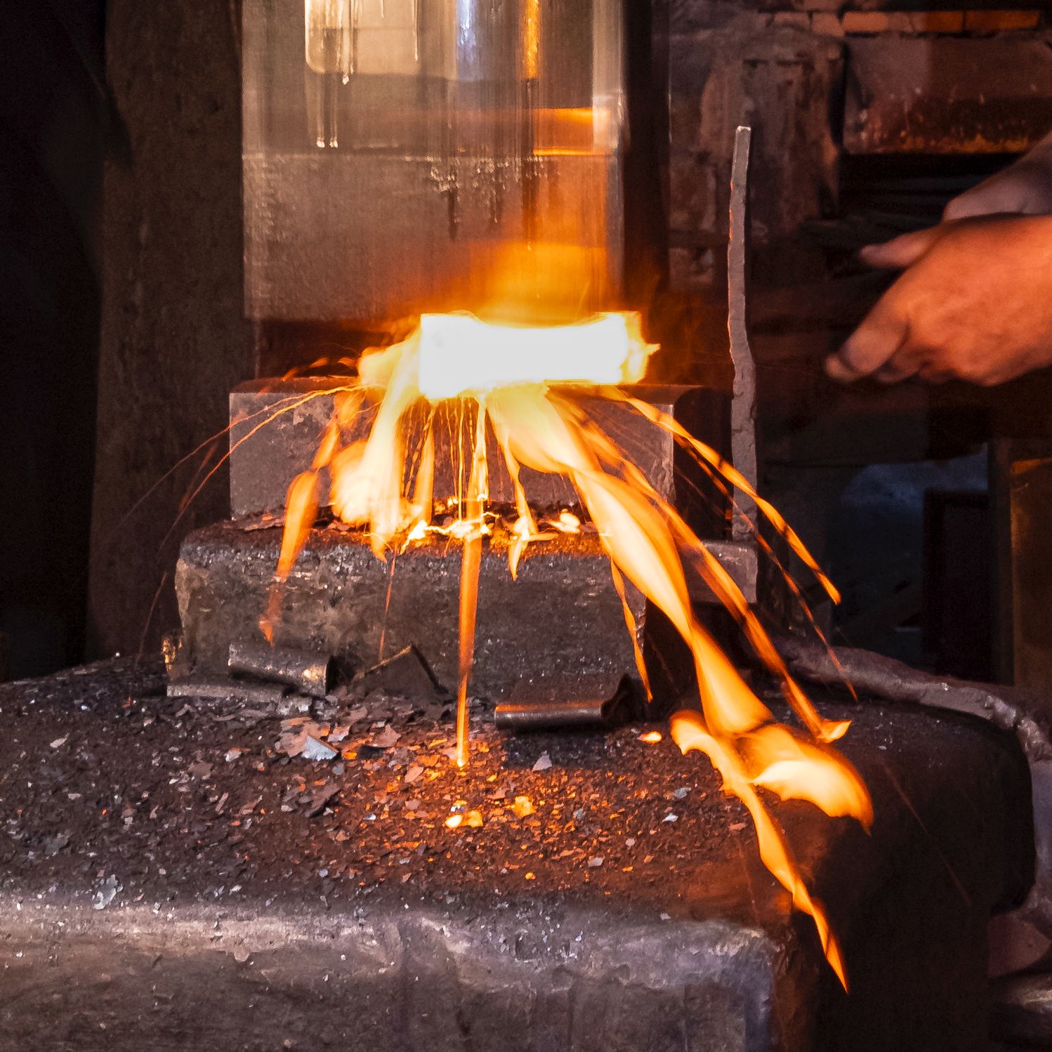Ein glühendes Stück Metall wird bearbeitet